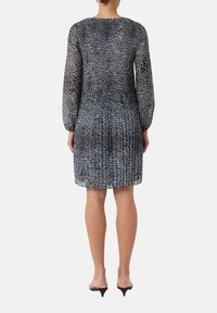 Schwarzes und graues Tiermusterkleid mit langen durchsichtigen Ärmeln, tailliertem Oberteil und plissiertem Rock, mit Rundhalsausschnitt und einer Länge bis zur Mitte des Oberschenkels.