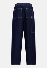 Marineblaue Denim-Hosen mit elastischem Bund, zwei Gesäßtaschen, kontrastierendem gelbem Stich und einer lockeren, weiten Beinform.