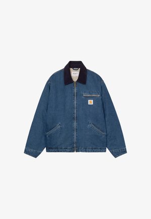 Giacca in denim blu con zip e colletto in velluto a coste scuro, due tasche frontali inclinate, tasca sul petto con zip e un'etichetta con logo sul petto.