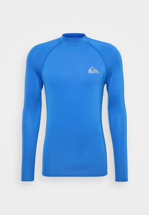 Long-sleeve rash guard in bright blue, made of smooth, stretchy fabric; features a small logo on the chest and a high neckline.