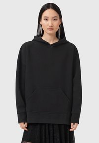 Felpa nera oversize realizzata in morbido tessuto, con tasca frontale e cappuccio regolabile, maniche lunghe e vestibilità rilassata.