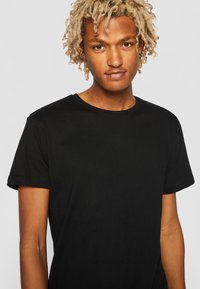Black cotton T-shirt with a crew neckline and short sleeves, featuring a smooth texture and simple, unadorned design.