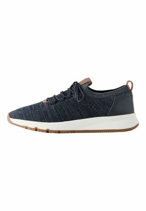 Low-top navy knit sneaker with black laces, brown leather accents, white midsole, and brown rubber outsole.