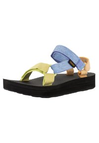 Sandales multicolores avec des brides jaunes, bleues et orange, semelle texturée noire et design à plateforme surélevée pour le confort.