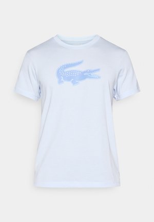 Camiseta de algodón azul claro con mangas cortas y cuello redondo. Presenta un gran diseño gráfico de un cocodrilo azul en la parte delantera.
