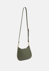 Bolso de hombro de cuero sintético color verde oliva con forma curveada, correa ajustable y herrajes metálicos en tono dorado. Textura suave, cierre con cremallera.