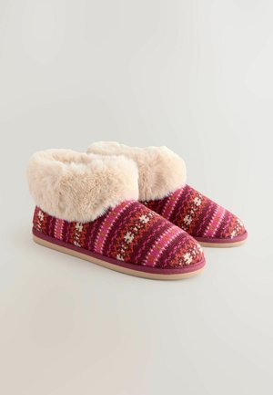 Karvased roosa ja punase mustriga sussid pehme kreemja kunstkarvkäe ja beeži kummi tallaga, mis pakuvad mugavat ja sooja disaini.