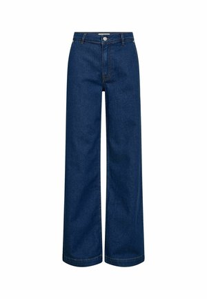 Laiade lõikega teksad tumeda sinise denimi kangast. Omadusteks on kõrge vöökoht, eesmine nööpidega kinnis ja nähtavad õmblused servadel.