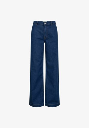 Laiade lõikega teksad tumeda sinise denimi kangast. Omadusteks on kõrge vöökoht, eesmine nööpidega kinnis ja nähtavad õmblused servadel.