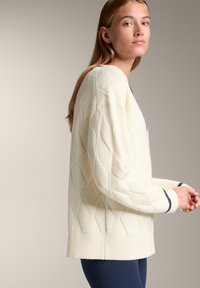 Cremefarbener Strickpullover mit Rautenmuster, mit gerippten Bündchen und Saum. Verfügt über einen weit geschnittenen, lässigen Schnitt und leicht übergroße Ärmel.
