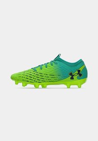 Green and blue soccer cleats with a textured upper, rounded toe, lacing system, and visible studs for traction. Logo on the side.