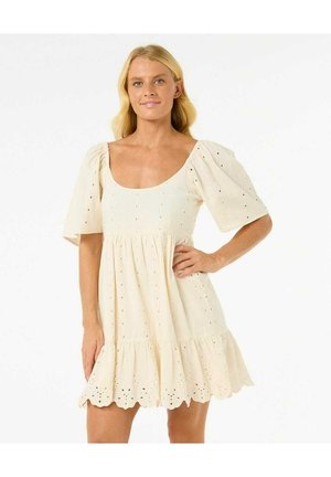 Robe à manches courtes, de couleur crème, en tissu léger. Elle présente un décolleté carré, un buste froncé, et des détails en œillets le long de l'ourlet.
