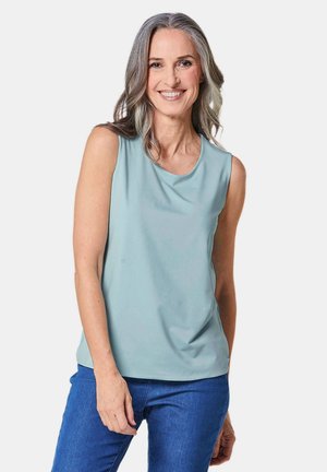 Top senza maniche in tessuto blu chiaro, con scollatura tonda e vestibilità rilassata, abbinato a jeans blu. Tessuto morbido con drappeggio delicato.