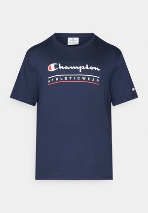 T-shirt en coton bleu marine avec un col rond, orné d'un graphique en texte blanc et rouge "Champion ATHLETICWEAR" sur la poitrine. Manches courtes.