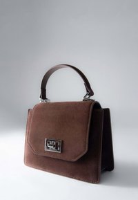 Brązowa torebka z zamszu o zwartej formie, z krótkim uchwytem i srebrnym zapięciem na przedzie. Gładka faktura, elegancki design.