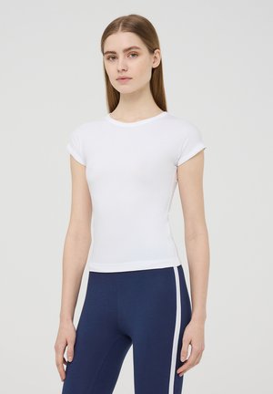 T-shirt bianco a maniche corte realizzato in morbido tessuto, con scollatura rotonda e forma aderente, abbinato a leggings blu scuro con strisce bianche sui lati.