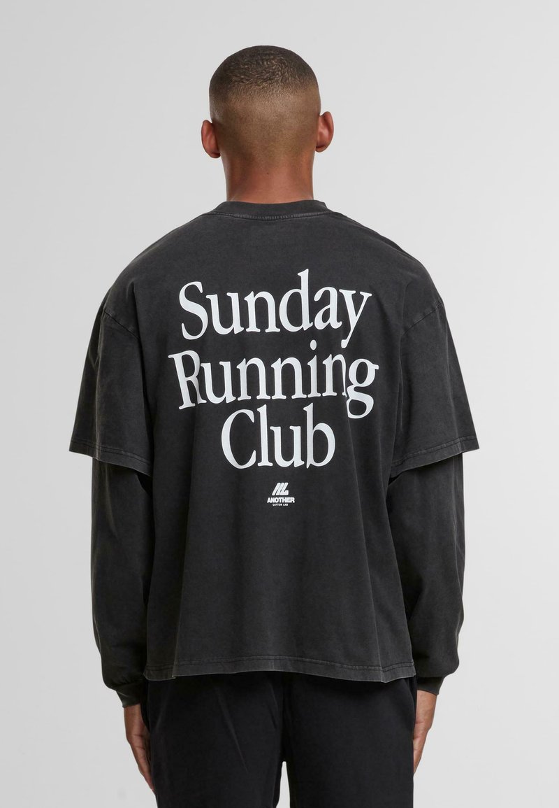 Czarna, oversize koszulka z krótkim rękawem, z napisem "Sunday Running Club" dużymi, białymi literami z tyłu, wykonana z miękkiej bawełny.