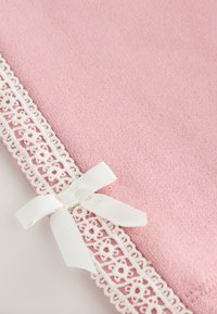 Tissu rose doux bordé d'une dentelle florale blanche et d'un petit nœud en satin blanc noué au coin.
