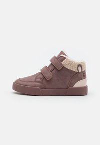 Baskets velcro mi-hauteur en mauve avec une doublure en crème peluche, un tissu texturé et une semelle en caoutchouc lisse. Bout arrondi avec des accents contrastés.