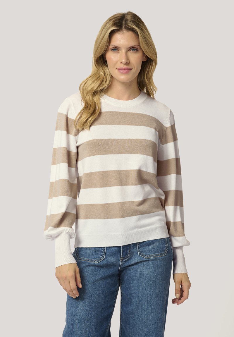 Pull en tricot rayé beige et blanc, avec un col rond, des manches bouffantes longues et des poignets côtelés. Assorti avec un jean bleu à coupe relaxée.