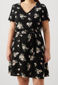 Robe noire à col en V et manches courtes, ornée d'un motif floral dans des tons de rose et de vert. Comprend une ceinture à nouer à la taille.