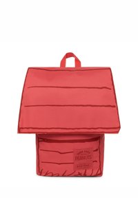 Mochila roja con una tapa que asemeja una casa, con patrones de líneas marrones. Incluye una etiqueta con las marcas "Peanuts" y "Eastpak".