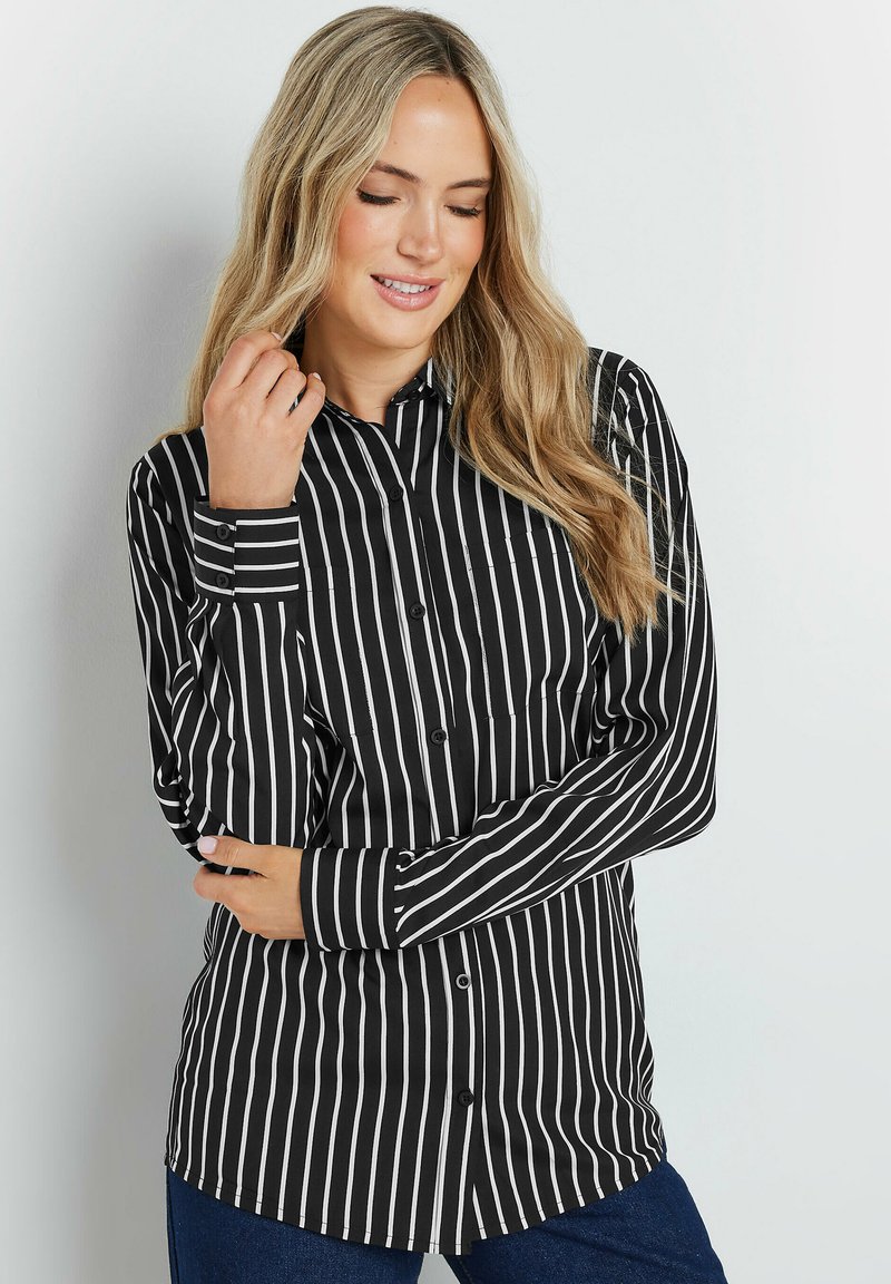 Camicia a righe bianco e nere con bottoni, maniche lunghe, colletto e orlo curvo. Il tessuto sembra liscio con un design aderente.