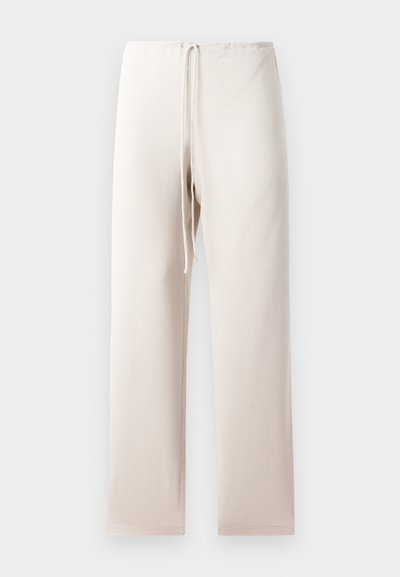 Licht beige stoffen broek met een rechte snit, voorzien van een elastische tailleband en trekkoord. Het materiaal lijkt zacht en glad.