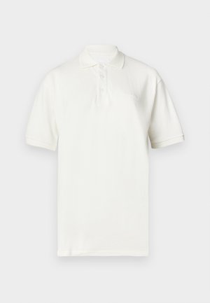 Hvit poloskjorte laget av bomull, med krage, korte ermer og tre knapper foran. Diskré brodert merke på brystet.