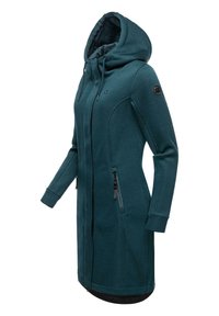 Veste longue à capuche en teal avec texture côtelée, deux poches zippées et accents noirs. Comprend une fermeture éclair pleine longueur et des poignets ajustés.