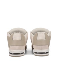 Beige sneakers with textured suede and smooth leather panels. Features a padded collar, perforated accents, and transparent air cushioning in the sole.