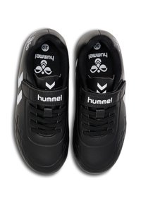 Des baskets noires avec une tige en synthétique lisse, des côtés texturés, un logo blanc et un design en chevron blanc contrastant. Fermeture à lacets et à sangle.