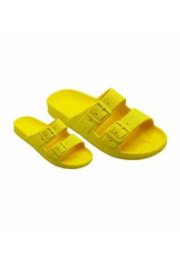 Sandales en mousse jaunes avec deux sangles réglables à boucles. Texture lisse, semelle intérieure profilée et semelle plate. Disponible en tailles adulte et enfant.