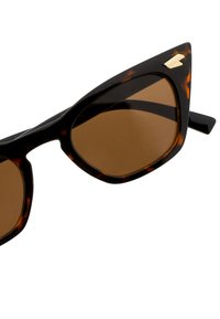 Smeše sunčane naočale smeđih nijansi s okvirom u uzorku kornjače, s oštrom mačkastom dizajnom i zlatnim detaljima.