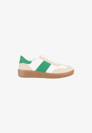 Baskets avec un corps en cuir blanc, des accents verts, une boîte à orteils en daim beige et une semelle en caoutchouc brun texturé. Elles présentent un design classique à lacets.