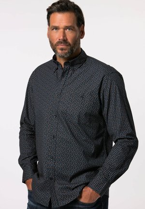 Camisa abotonada azul marino con un pequeño patrón geométrico en naranja. Presenta un cuello clásico y mangas largas con puños abotonados.