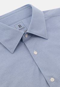 Camicia a righe blu e bianche con colletto a punta, due bottoni e una texture di tessuto liscia con etichetta del marchio.