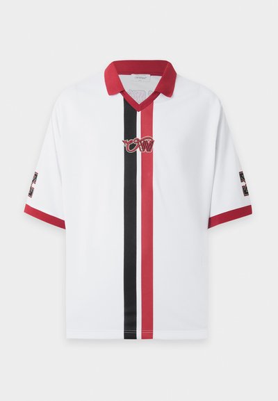 Chemise blanche à manches courtes avec col rouge, rayures verticales rouges et noires et bordure des manches assortie, avec un logo stylisé sur la poitrine et les manches.