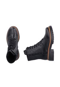 Bottines en cuir noir avec un bout rond, un design à lacets et une semelle épaisse. Présente un cuir texturé et une bordure cloutée sur le côté.