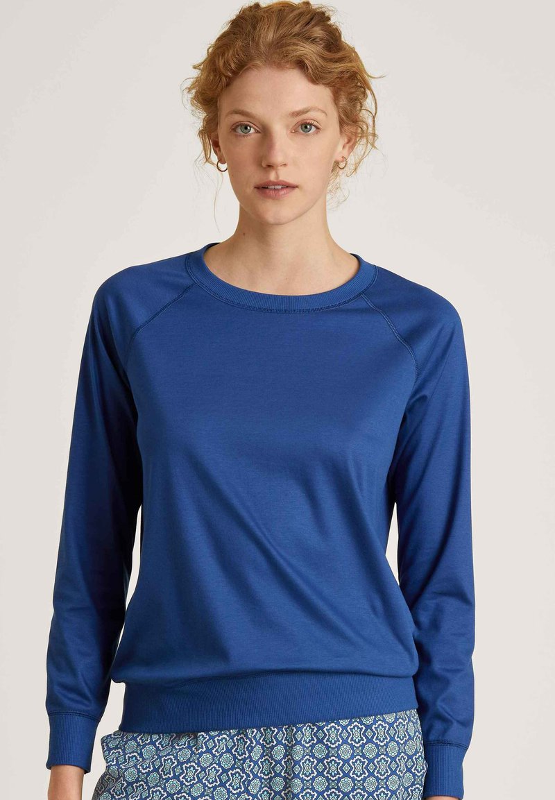 Blauw langemouwen sweatshirt met een ronde halslinie en geribbelde manchetten. Glad materiaal met een getailleerde silhouette en subtiele stiksels.