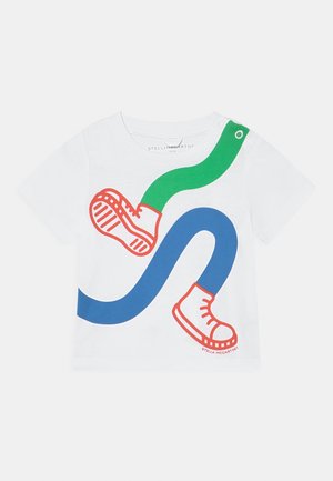 T-shirt in cotone bianco con un design grafico giocoso, caratterizzato da linee curve blu e verdi e illustrazioni di scarpe rosse sul davanti.