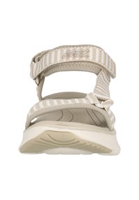 Ljust beige sandal med texturerade tygremmar, justerbart spänne och vadderad sula. Har ett zigzag-mönster på remmarna för bra grepp.