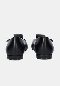 Bailarinas de cuero negro con una textura suave, puntera redondeada y tacón plano; presentan un diseño sencillo y un pequeño lazo decorativo en la parte trasera.