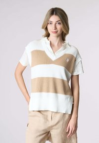 Pullover a strisce crema e beige con colletto a V. Maniche corte, texture intrecciata e un piccolo emblema sul petto.