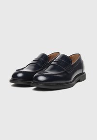 Mocasines de piel azul marino con un brillo suave, que presentan dos correas superiores y una suela cosida. Diseño clásico con punta redonda y tacón bajo.
