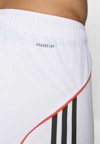 Hvide atletiske shorts med et sort og rødt stribedesign. Har "AEROREADY" logoet på taljen og tre sorte lodrette striber på siden.