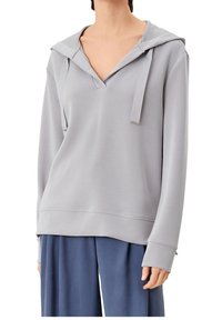 Sudadera con capucha gris claro, con escote en V, mangas largas y detalles de cordones; presenta una textura suave y un ajuste relajado.