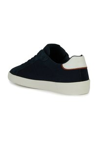 Sneaker in suede blu navy con un accento bianco e marrone sul tallone, caratterizzato da un profilo basso, suola in gomma e dettagli con lacci sul lato.