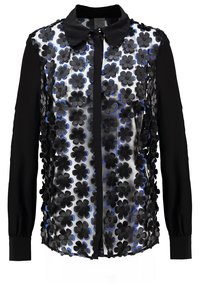 Svart långärmad skjorta med knäppbar krage, försedd med en genomskinlig framdel prydd med svarta och blåa blommiga applikationer. Strukturerad tyg.