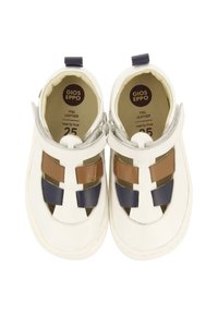 Zapatos de cuero blanco con detalles en marrón y azul marino. Presentan un diseño de punta cerrada con correas y cortes para ventilación. Talla 25.